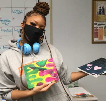 Student holding her artwork