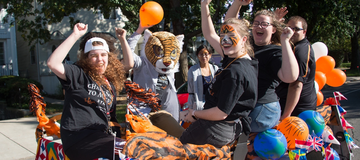 Homecoming parade float with students cheering